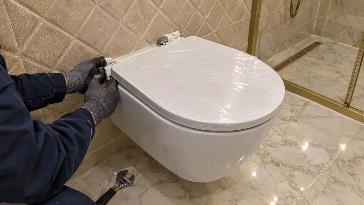Yeni asma klozete yavaş kapanan kapak menteşesi takılıyor